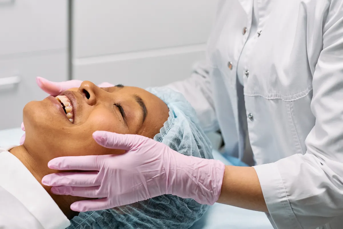 Clinician examining a patient's face during an aesthetic assessment