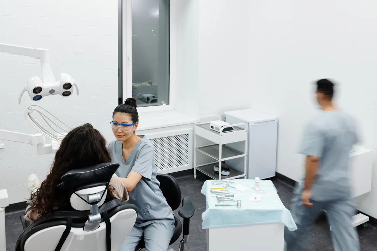 Dental clinic room where staff attend a patient together